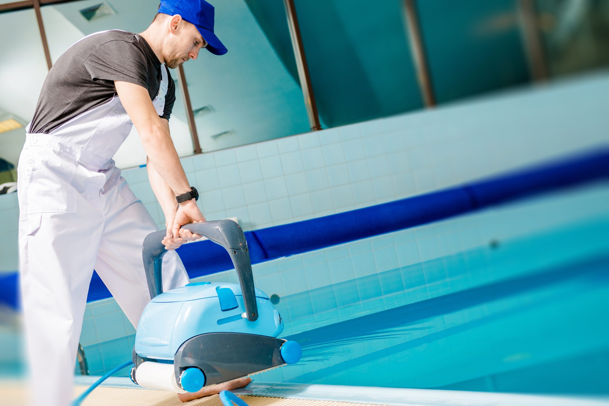 Swimming Pool Technician with Automated Pool Cleaner Preparing For Cleaning.